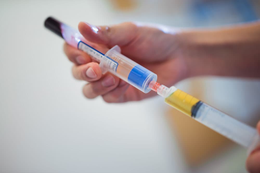 Close-up of syringe preparation in a medical setting